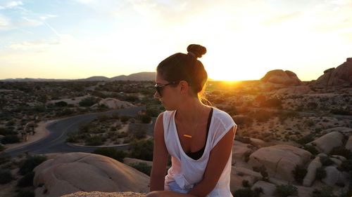 Young woman sitting on cliff at joshua tree national park