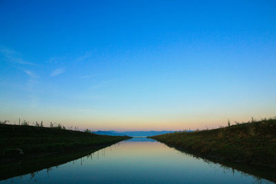 Scenic view of lake against clear blue sky