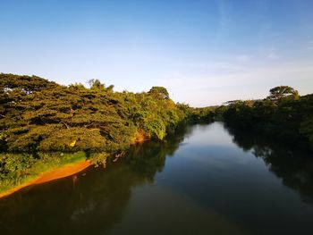 Scenic view of lake by trees against sky