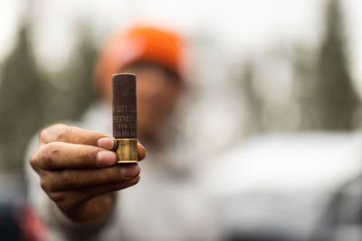 Close up of person holding single bullet.