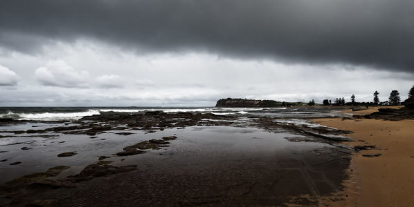 View of beach against cloudy sky