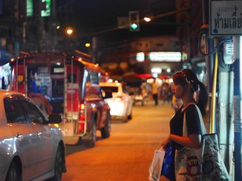 Rear view of man on city street at night