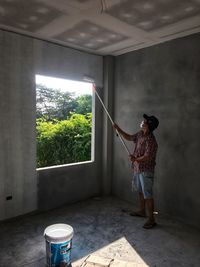 Rear view of woman standing by window