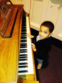 Boy playing piano at home
