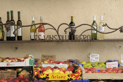 Multi colored bottles on shelf against wall