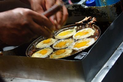 Cropped image of man boiling eggs on stove