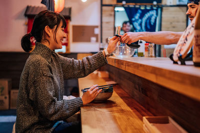 Woman using mobile phone at table