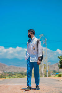 Full length of man standing against blue sky