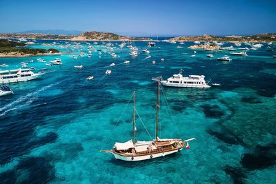 High angle view of sailboat sailing in sea against blue sky