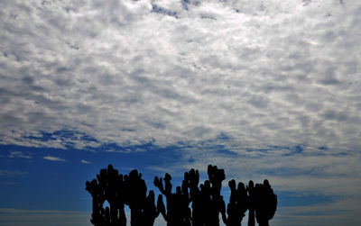 Silhouette of people against cloudy sky