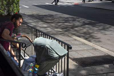 High angle view of people sitting on bench in city