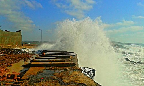 Waves splashing on sea against sky