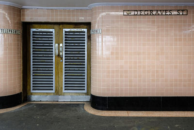 Signs on tiled wall of telephone booth