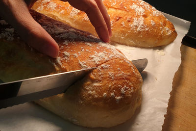 Close-up of hand holding bread on table