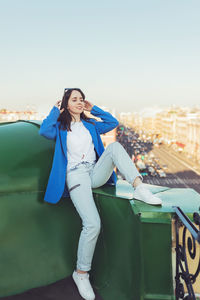 Side view of young woman standing against clear sky