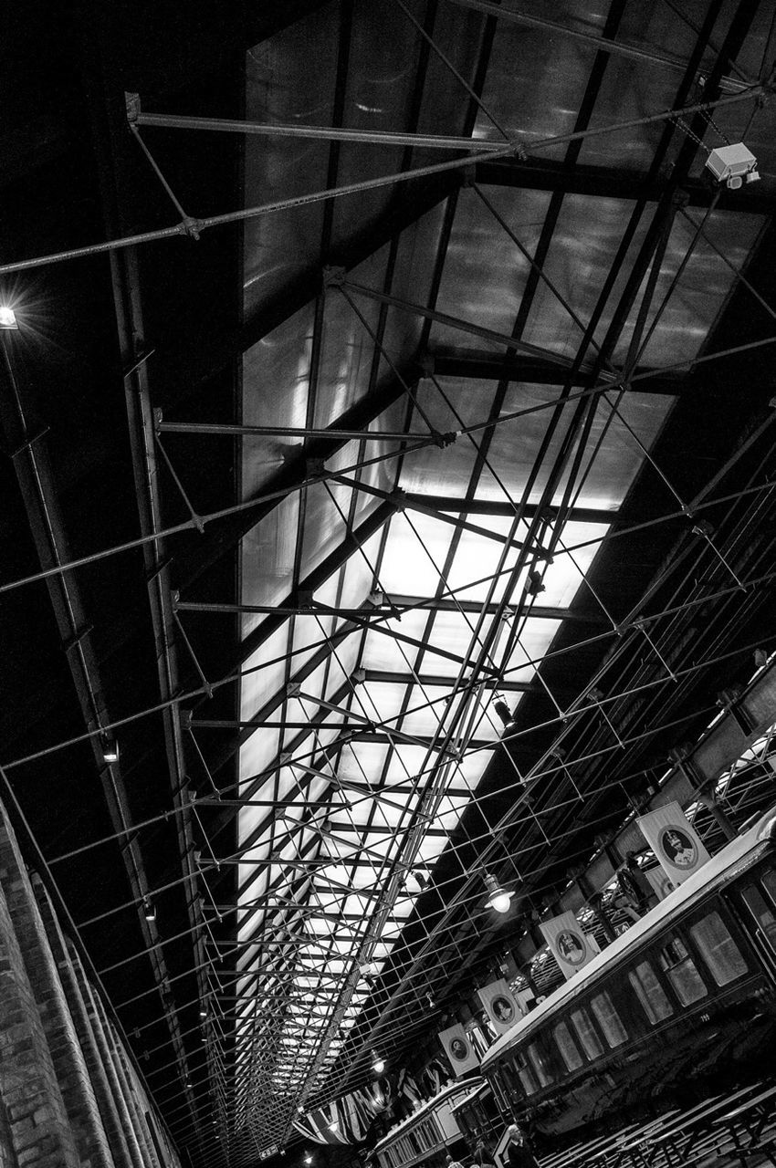 architecture, built structure, low angle view, indoors, ceiling, modern, illuminated, glass - material, building exterior, city, building, railroad station, no people, night, window, city life, architectural feature, pattern, reflection