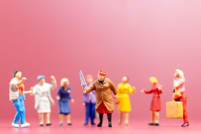 Close-up of figurines against yellow background