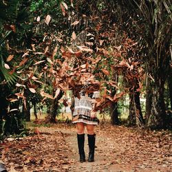 Full length of woman standing against trees