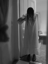 Rear view of woman standing at home