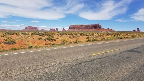 Road by landscape against sky