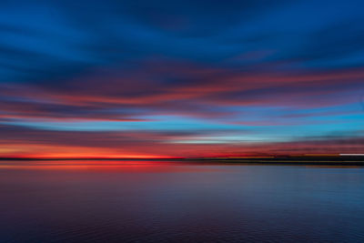 Scenic view of sea against dramatic sky during sunset