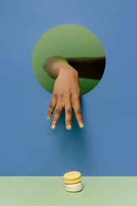 Midsection of woman with ball against blue background