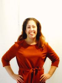 Smiling young woman standing against wall