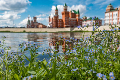 Scenic view of lake by buildings against sky