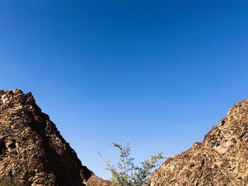 Low angle view of rock formation against clear blue sky