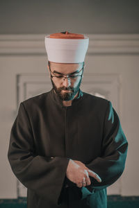 Midsection of man standing against wall