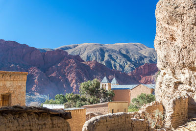 Houses against mountain on sunny day