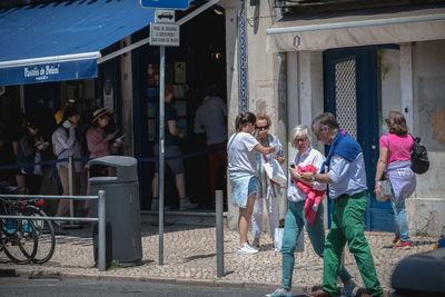 Group of people walking on street in city