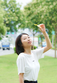 Side view of young woman holding flower