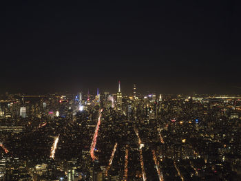 High angle view of illuminated city against sky at night