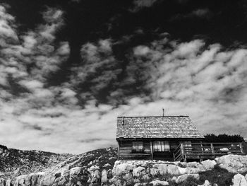 Low angle view of wooden house against cloudy sky