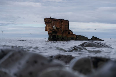 Abandoned built structure on beach against sky