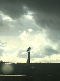 Silhouette smoke stacks against sky