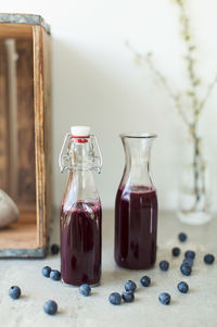 Close-up of juice in bottles with blueberries on table