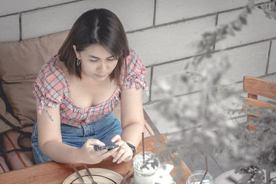 Young woman looking at camera while sitting in laptop