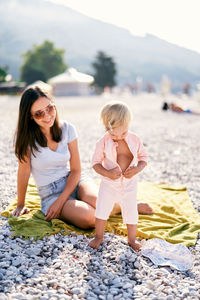 Side view of woman sitting on beach