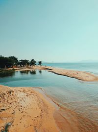 Scenic view of beach against clear blue sky