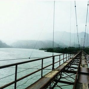 Scenic view of river by mountains against sky