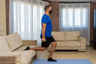 Full length of man exercising at home