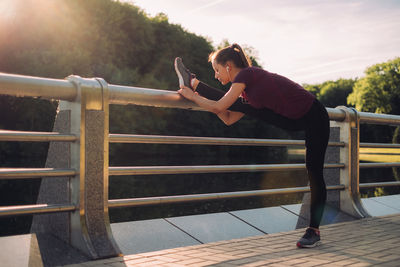 Side view of woman standing on railing