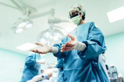 Doctor showing stained hands in operating room