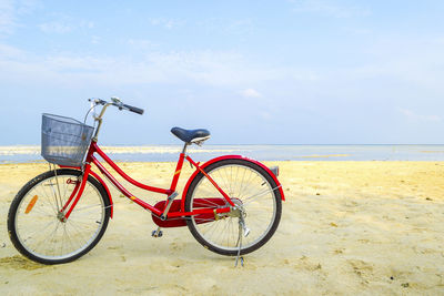 Bicycles on beach against sky