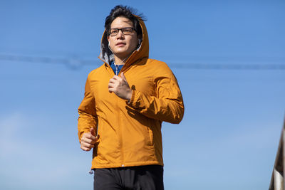 Young man running against sky