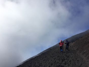 Friends hiking at mt fuji against cloudy sky