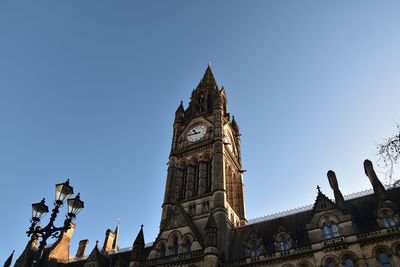 Low angle view of clock tower against clear blue sky