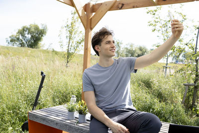 Portrait of young man sitting on field